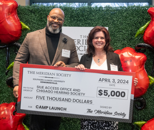 Dominic Dorsey and Amy Miller holding a large check from the Meridian Society