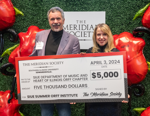 John Korak and Alicia Canterbury holding a large check from the Meridian Society