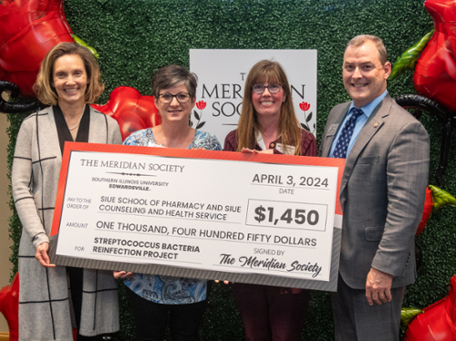 Dean Luer, Miranda Wilhelm and two representatives from the School of Pharmacy holding a large check from the Meridian Society