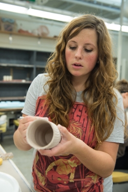 Madalyn Burroughs works on the cup she created using the 3D printer.