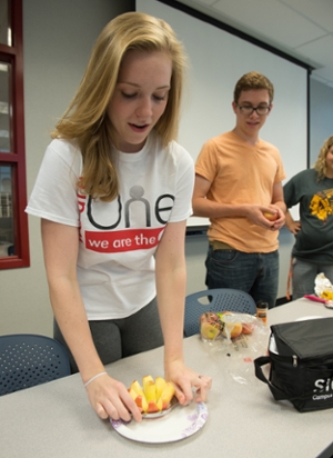 Hannah Greenwalt cuts an apple during the Fit into College program’s course on the topic of nutrition.