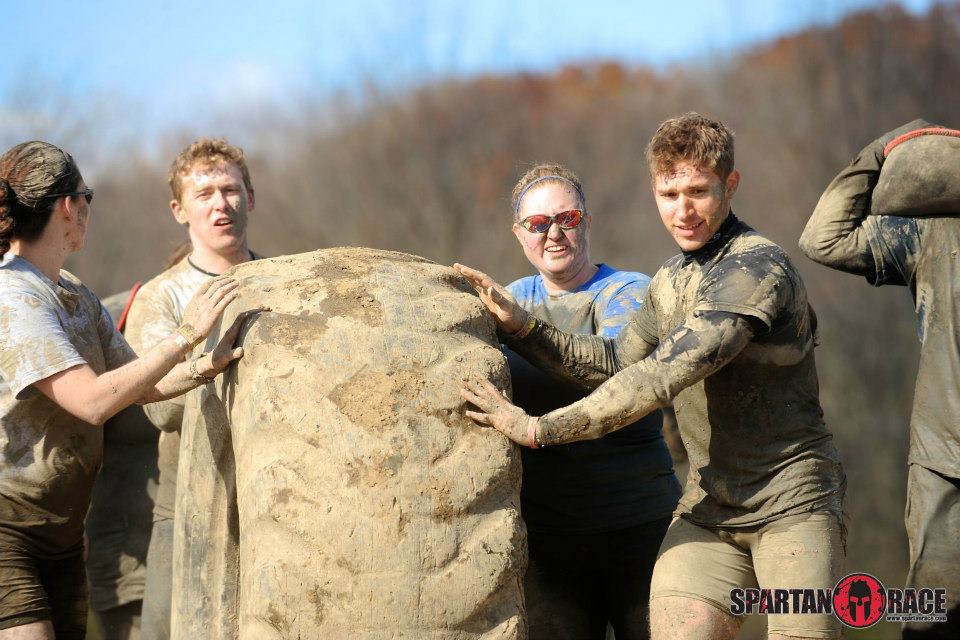 Racers rolling a giant tractor tire.