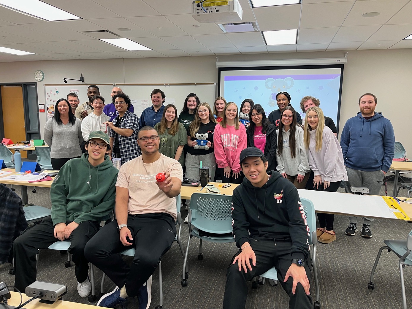 22 students standing and sitting as a group with smiles