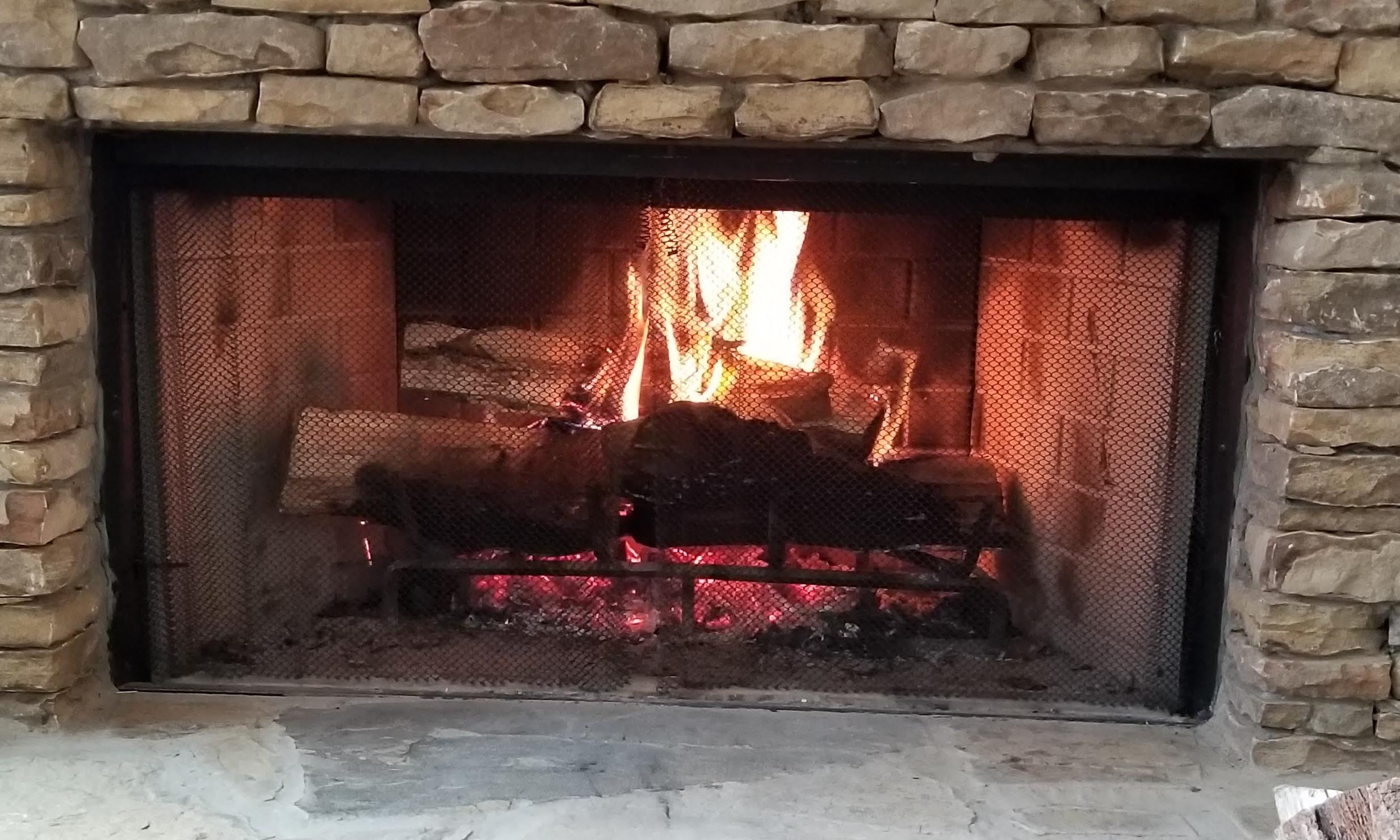 stone fireplace with fire burning